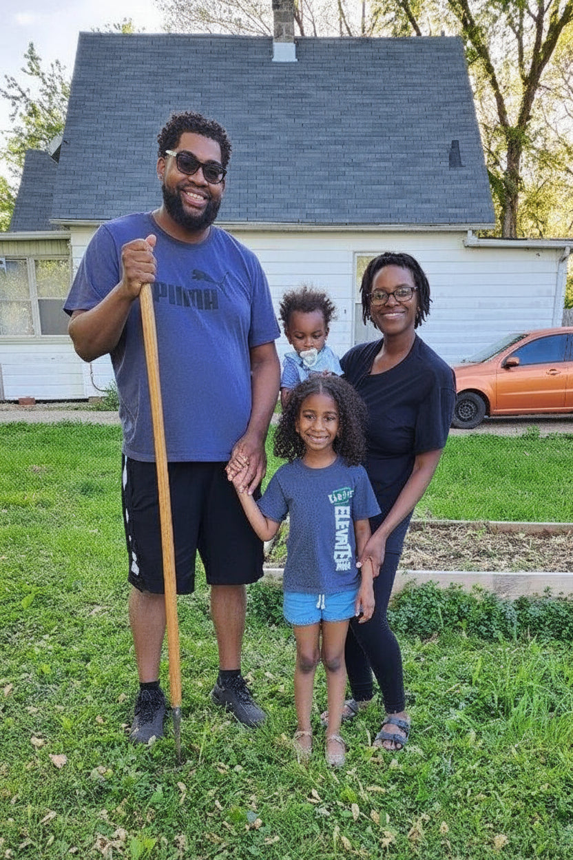 Family of four with a stroller in a residential yard.