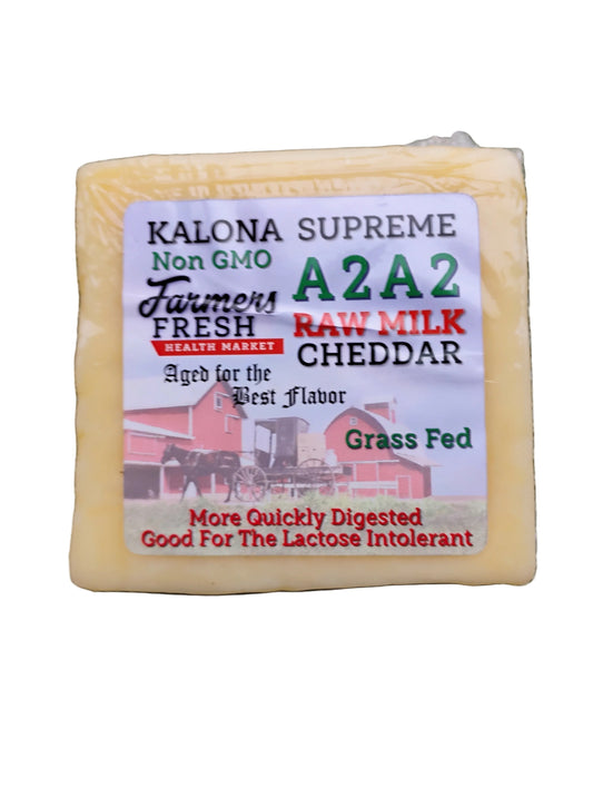 Block of Kalona Supreme A2A2 Cheddar cheese with a label on a white background.