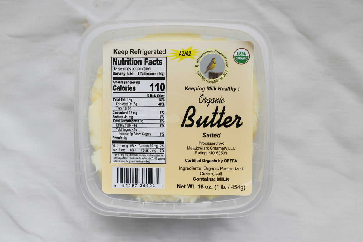 Container of organic salted butter with label on a white background